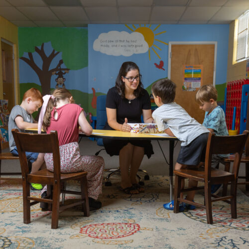 Katy Duckstein sits with children at a table during her Pennsylvania hybrid homeschool program