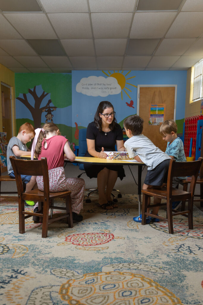 Katy Duckstein sits with children at a table during her Pennsylvania hybrid homeschool program