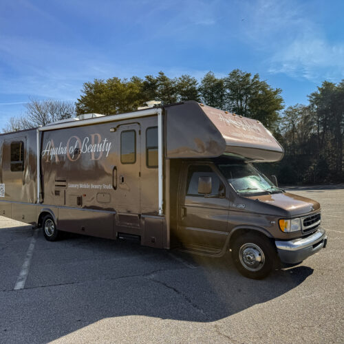 Brown RV branded Ayaba of Beauty, Brandi's luxury mobile beauty salon, parked in a lot