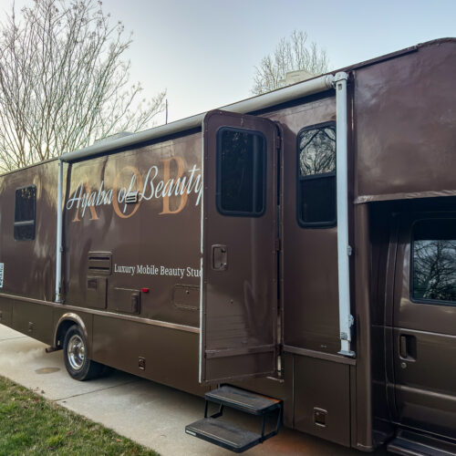 Brown RV with open door reading Ayaba of Beauty Luxury Mobile Beauty Studio