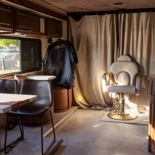 Interior of mobile salon trailer with white styling chair and Glow Club robe hanging