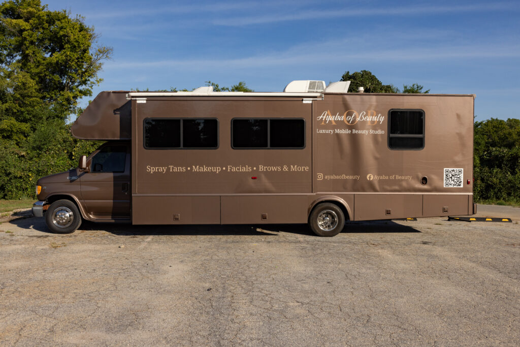 Brown RV converted into Ayaba of Beauty mobile studio offering spray tans, makeup, facials, and brows