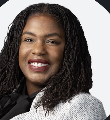 Woman with long locs smiling in a circular portrait, wearing a tweed blazer