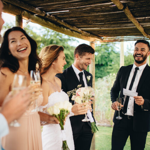 Best man gives speech to bride and groom during outdoor wedding reception toast