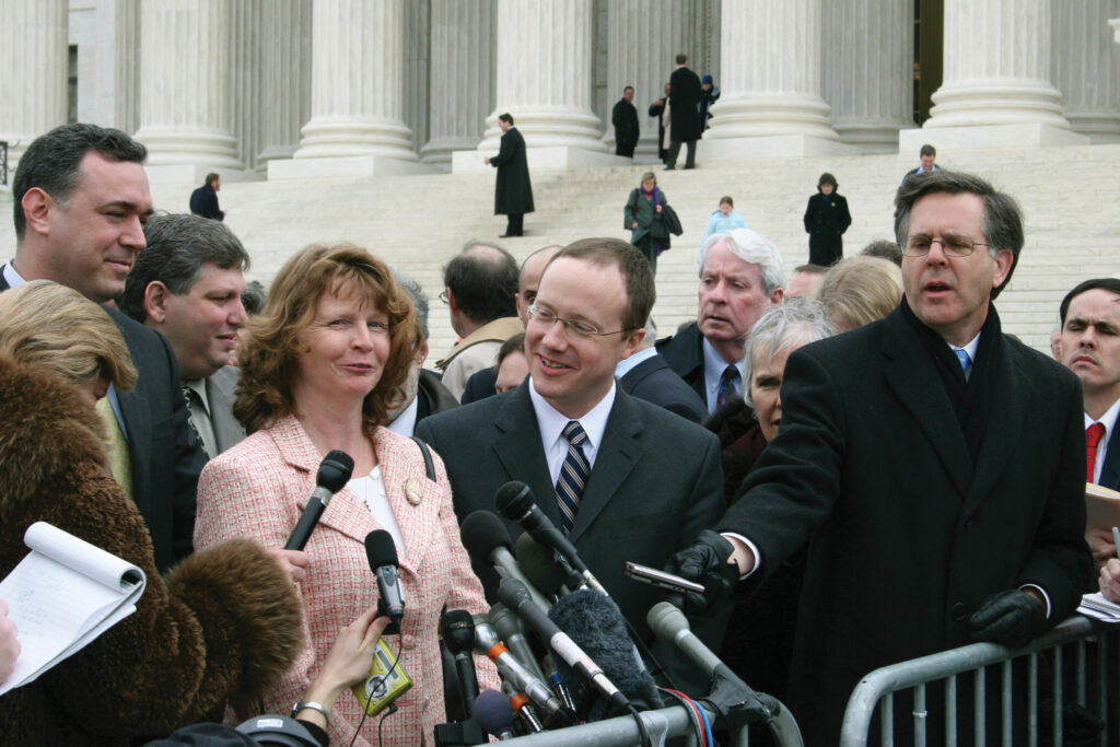Susette Kelo and Scott Bullock speak to reporters and microphones outside the U.S. Supreme Court