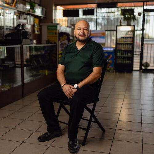 Mario Ayala sits on a chair inside Ayala's Mini Market, his convenience store in Glendale, Arizona.