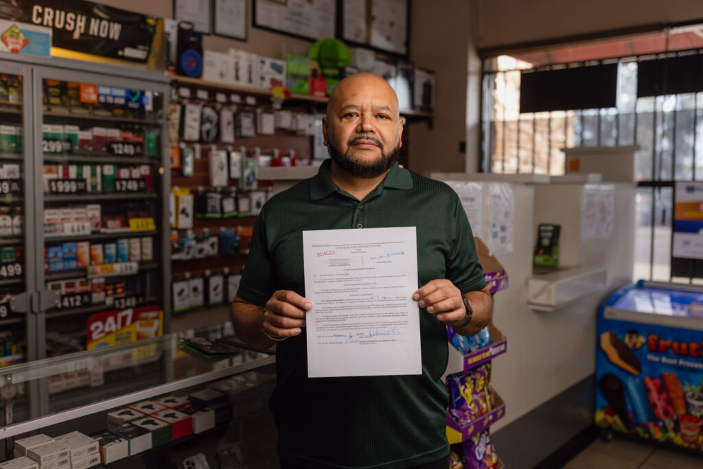 Convenience store owner holding a sealed federal search and seizure warrant document