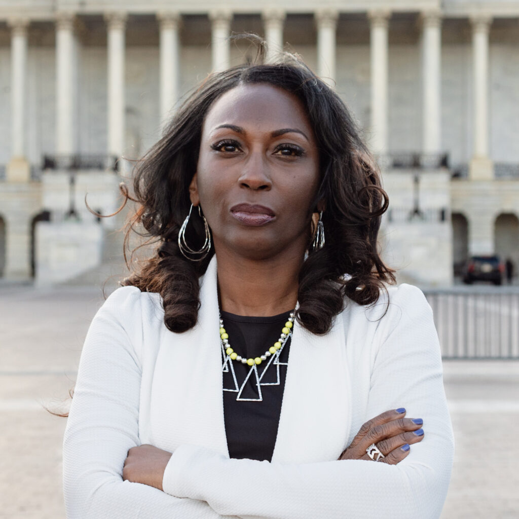 Woman with arms crossed stands outside the U.S. Capitol building
