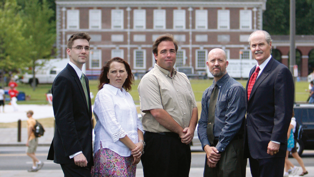 Tour guides Ann Boulais, Josh Silver, and Mike Tait stand with IJ attorneys Robert McNamara and Chip Mellor outdoors
