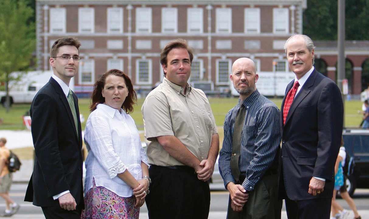 Tour guides Ann Boulais, Josh Silver, and Mike Tait stand with IJ attorneys Robert McNamara and Chip Mellor outdoors