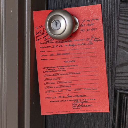 Red code violation notice on door citing home occupation violation at Rosi Paredes' daycare in Venus, Texas