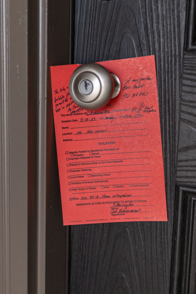 Red code violation notice on door citing home occupation violation at Rosi Paredes' daycare in Venus, Texas