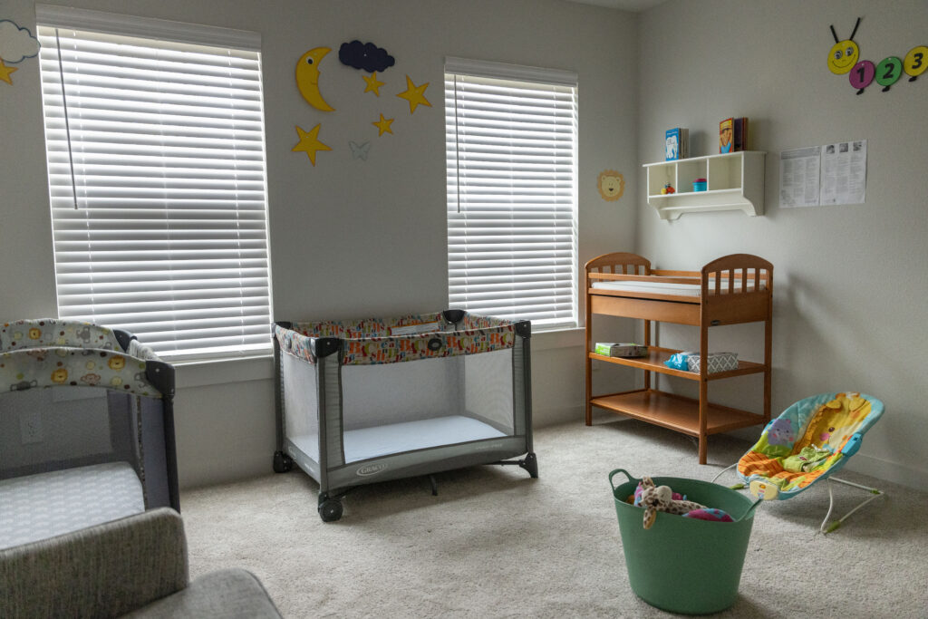 Nursery with cribs, changing table, and toys at Rosi Paredes's Venus, Texas home daycare