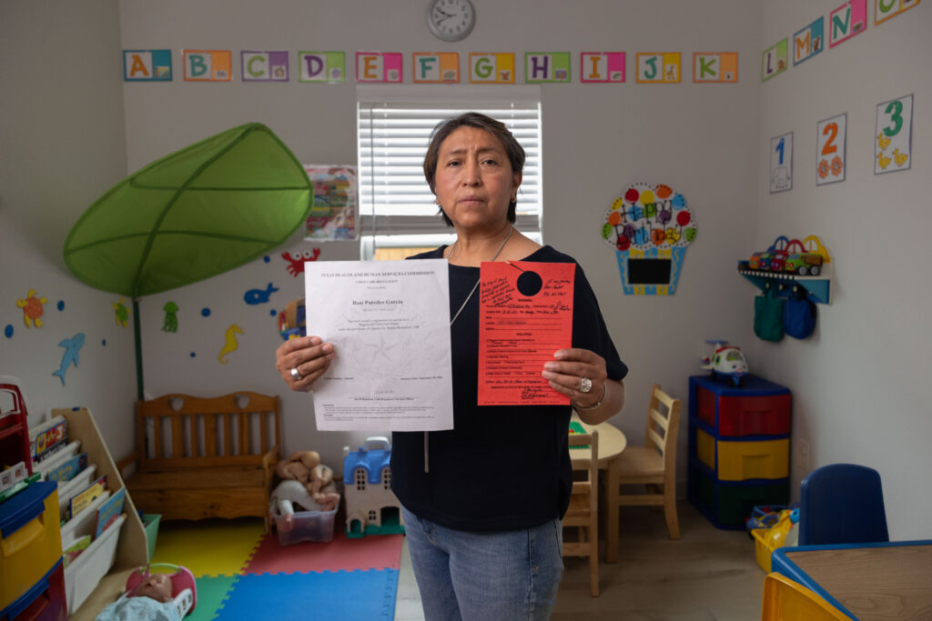 Rosi Paredes Garcia holds state child care license and Venus, TX violation notice in her home daycare