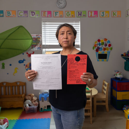 Rosi Paredes Garcia holds state child care license and Venus, TX violation notice in her home daycare