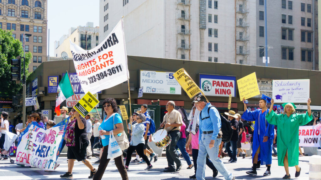 Crowd marching with immigration reform signs and banners during a Los Angeles street rally